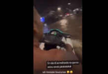 Homem pilota moto aquática em bairro alagado no Rio